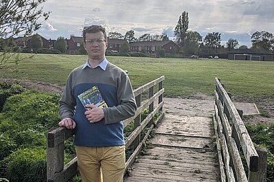 Cllr Will Frass stood with the old bridge Cllr Will Frass stood with the old bridge